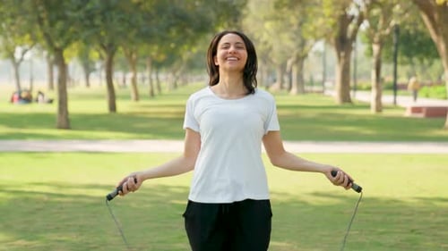 Woman Jumps Rope for Fitness in Sunny Park
