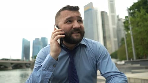 Young Handsome Businessman Talking on Mobile Phone in the City 40s