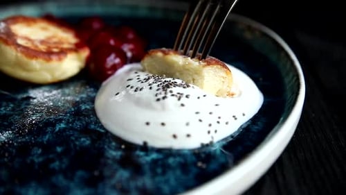 Syrniki Dessert with cherries and creamy sauce