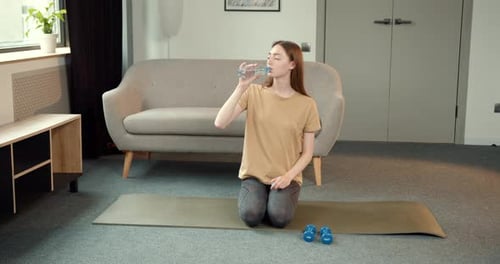 Young Woman Drinking Water After Workout