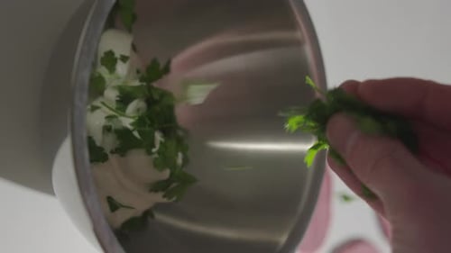 Sprinkle fresh parsley into mixing bowl with yogurt. Vertical 4K