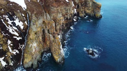 Flying Over Rocky Coastline Alongside Cliffside with Blue North Atlantic Ocean Water