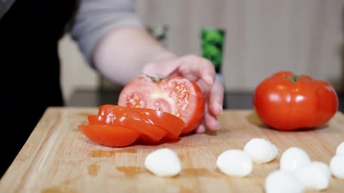 Bright Red Tomato Being Sliced in Kitchen