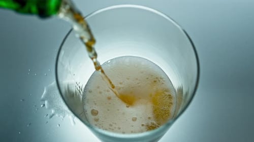 Beer pouring into glass with frothy bubbles