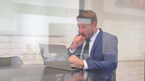 Mature Adult Working at Laptop in Office