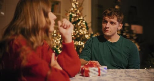 Man Apologizing Female Friend While Giving Her Gift
