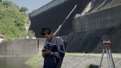 Blue collar worker is working at the dam.