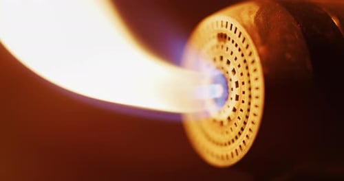 Slow motion macro of glass blowing process by professional worker with hot flame in a workshop. Sh