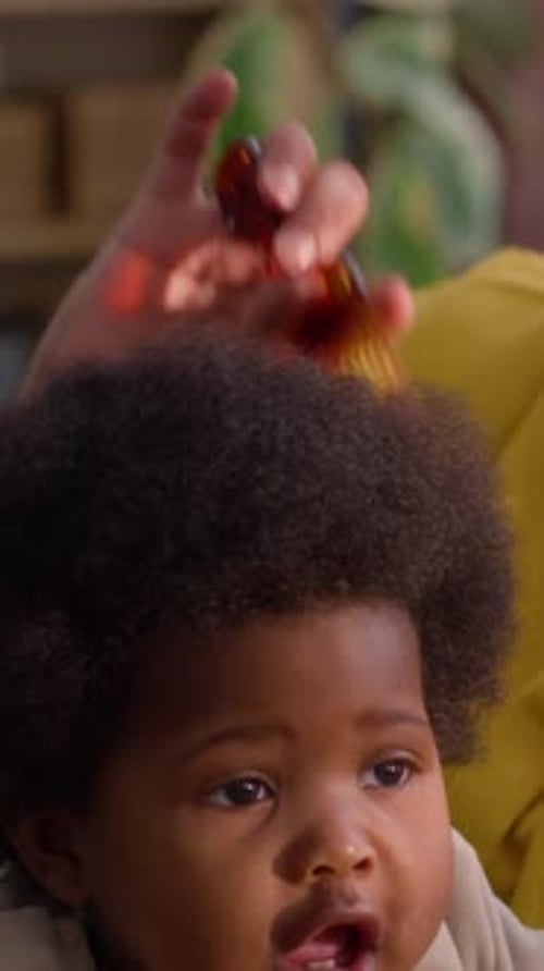 Adult Combs Infant's Hair at Home