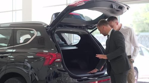 Dealer Center for the Sale of New Cars A Man Examines the Interior of a Car Concept of Auto Business