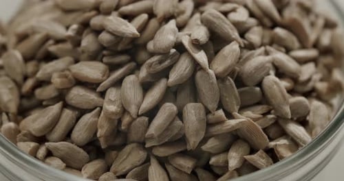 Peeled Sunflower Seeds Filling Glass Bowl close up