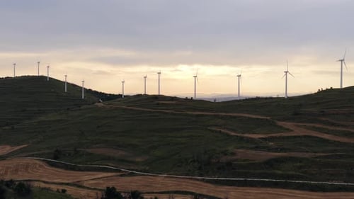 Wind Turbines on Rolling Hills at Sunset by Drone
