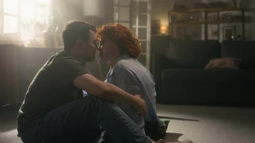 Loving Couple Embrace on Floor Indoors At Home