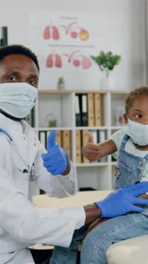 Doctor and Little Girl Giving Thumbs Up in Hospital