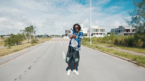 Homem estiloso afro-brasileiro fica na rua com as mãos estendidas