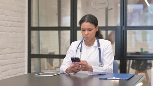 African Female Doctor Using Smartphone in Hospital