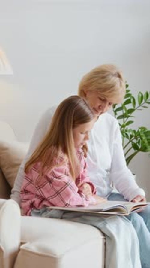 Child and Senior Reading a Book Together