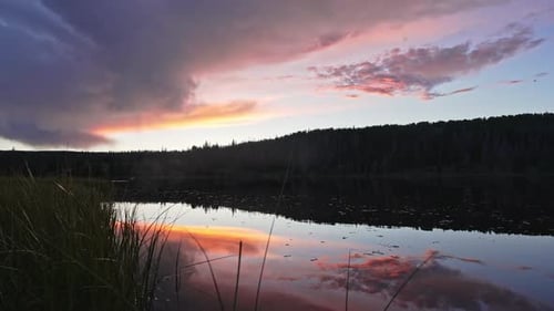 Sunset reflecting on pond panning over the grass