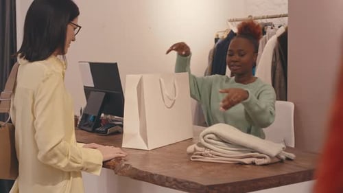 Woman Buying Clothes at Designer Showroom
