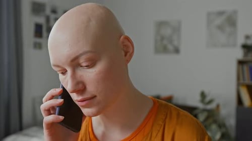 Close-up of Young Woman with Alopecia Taking Phone Call from Home