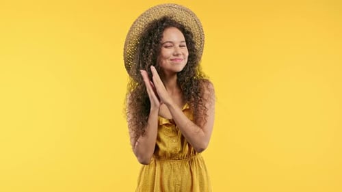 Smiling Woman Clapping Hands with Yellow Background
