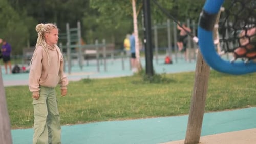 Girl and Boy Swinging on Round Rope Swing in Park Children Having Fun Playing on Outdoor Public