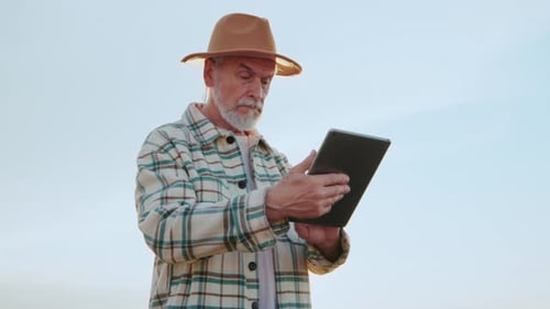 Close Up Farmer Agronomist Use Tablet Computer in Field Wheat Senior Farmer the Business Owner Check