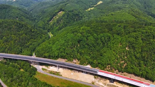 Highway curves through lush green hills. A highway winds through dense green forests