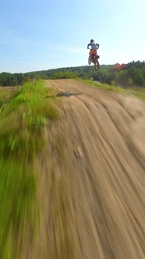 Motocross Rider Jumps High on Dirt Track, Aerial View