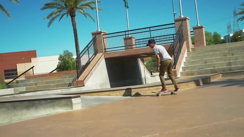 Young male Skateboarder doing a jump at Skate Park on Skateboard, Wide Shot Slow Motion