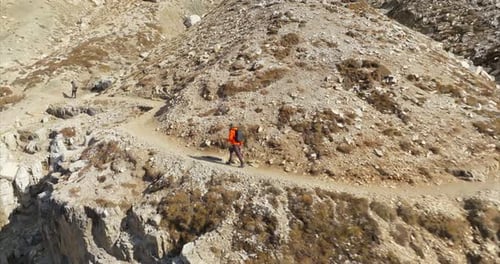 Randonneur marchant sur le sentier des Dolomites alpines, suivi d'une photo aérienne