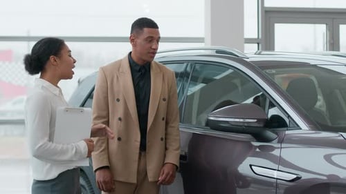Car Saleswoman Explaining Features to a Potential Buyer