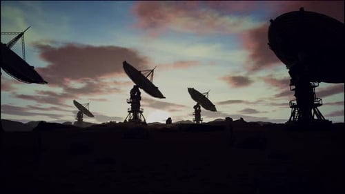 Satellite Dishes On Field Against Cloudy Sky During Sunset
