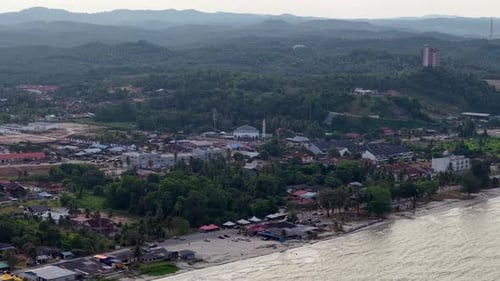 Aerial View of Beachside Town with Lush Green Hills