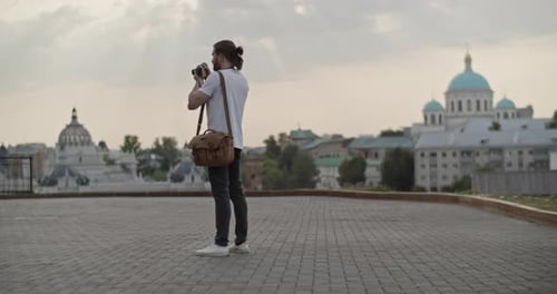 Man Photographs European Buildings on Overcast Day