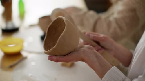 Artisan Hands Skillfully Shaping Clay Pot on Potter's Wheel in Workshop