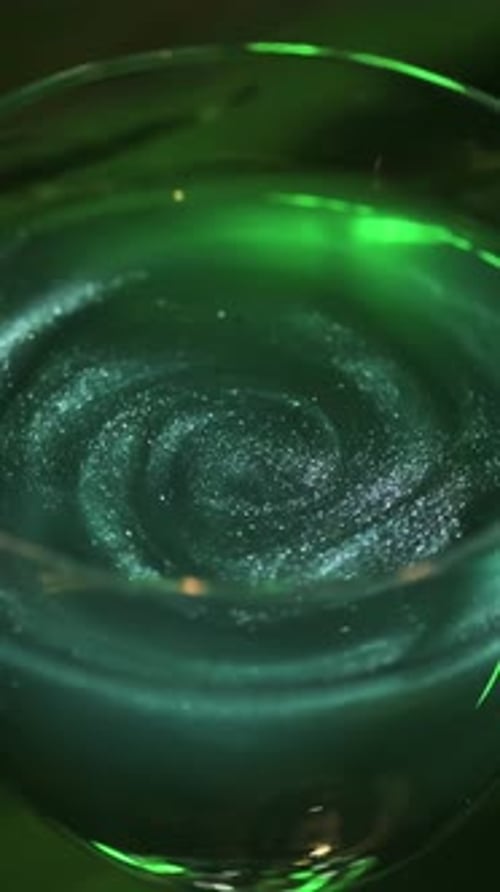 Wine Glass with Green Coctail on Dark Green Background with Plant Leaves Stock Footage Close Up of