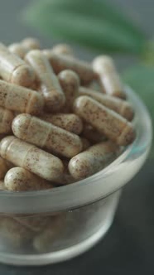 Natural Herbal Capsules Arranged in a Clear Bowl