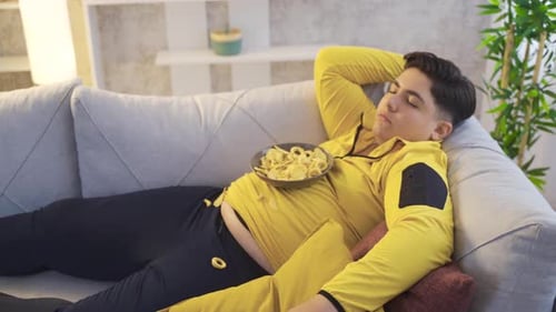 Young Adult Napping with Chips on Couch