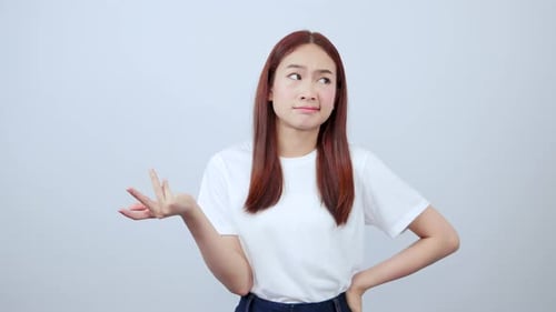 Frustriertes asiatisches Mädchen zuckt mit den Schultern und sieht genervt und genervt aus, weil es nicht versteht, darin zu stehen-