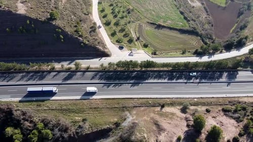 Luftbild eines Lastwagens und eines Lieferwagens, die auf einer offenen Landstraße in Europa fahren