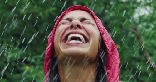 Woman Laughs in the Rain Wearing a Red Jacket