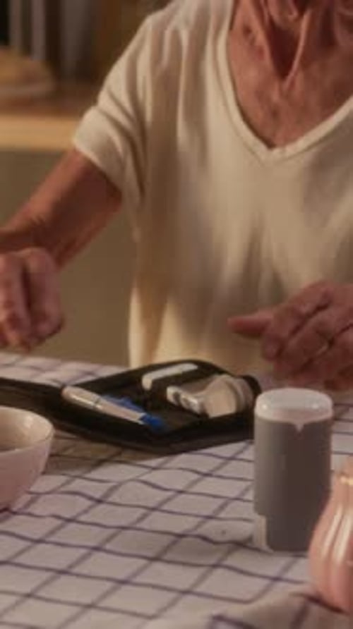 Senior Woman Checks Blood Sugar Level at Home