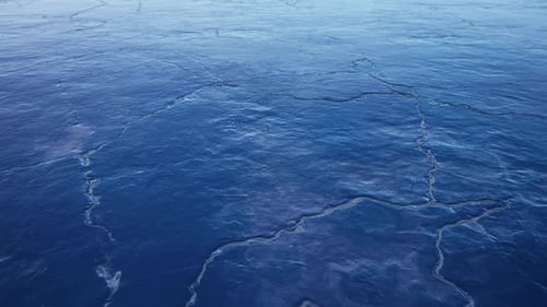Ice Cracks Forming On A Frozen Lake During A Winter Day