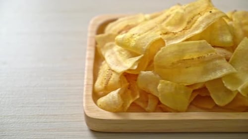 Golden Banana Chips on Wooden Platter