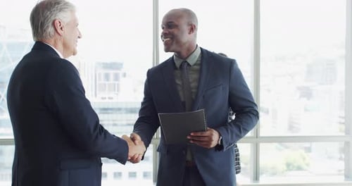 Businessmen Shaking Hands in a Modern Office Setting