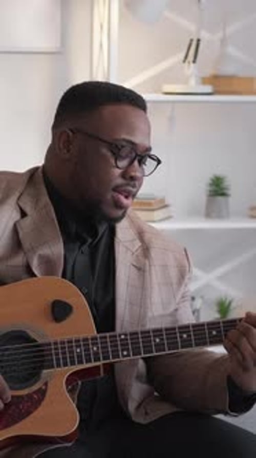 Man Plays Acoustic Guitar and Sings