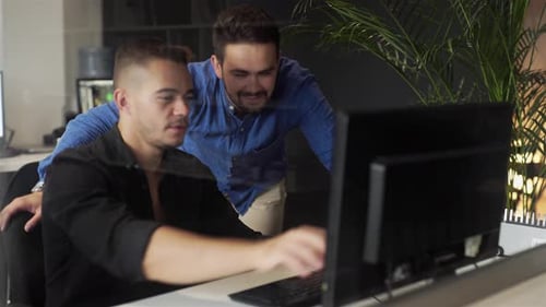 Men Collaborating on Computer in Modern Office