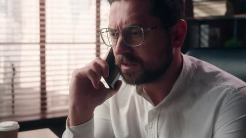 Adult Man Talking on Smartphone in Office Setting