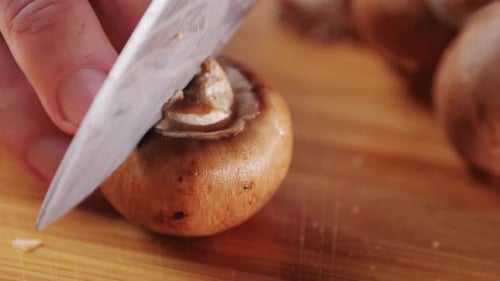 Chef Cutting the Mushrooms on a Wooden Board with Knife Mushroom Cooking Close Up